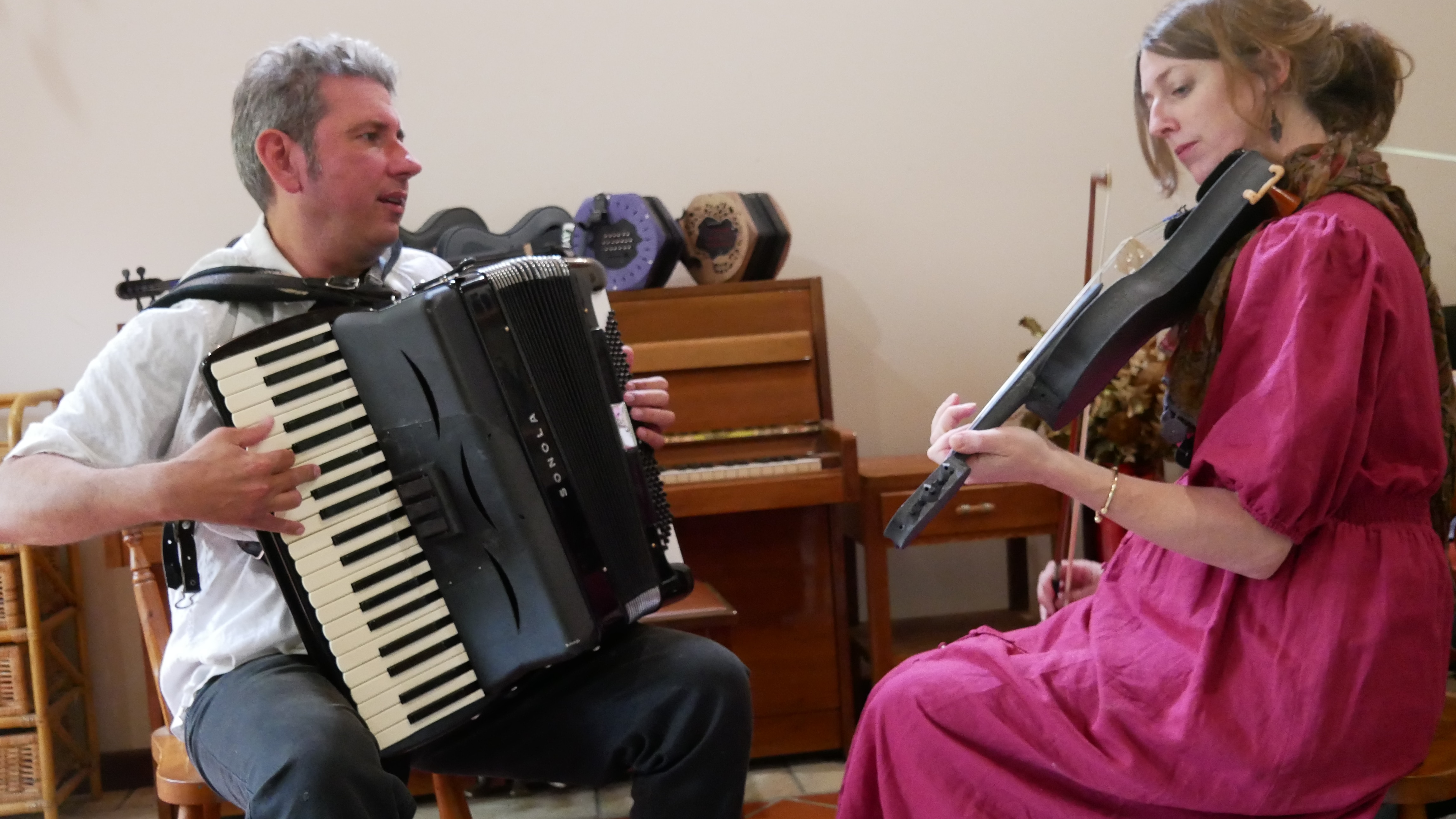 Two people seated playing instruments
