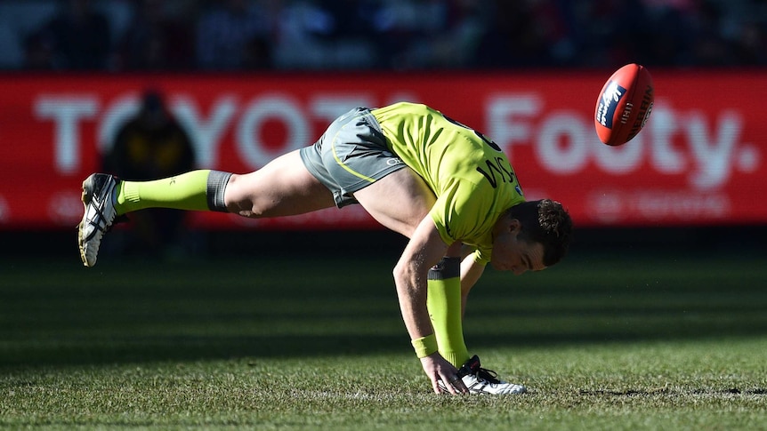 AFL umpire bounces the ball