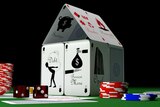 Image of a house made up of playing cards with gambling chips nearby.