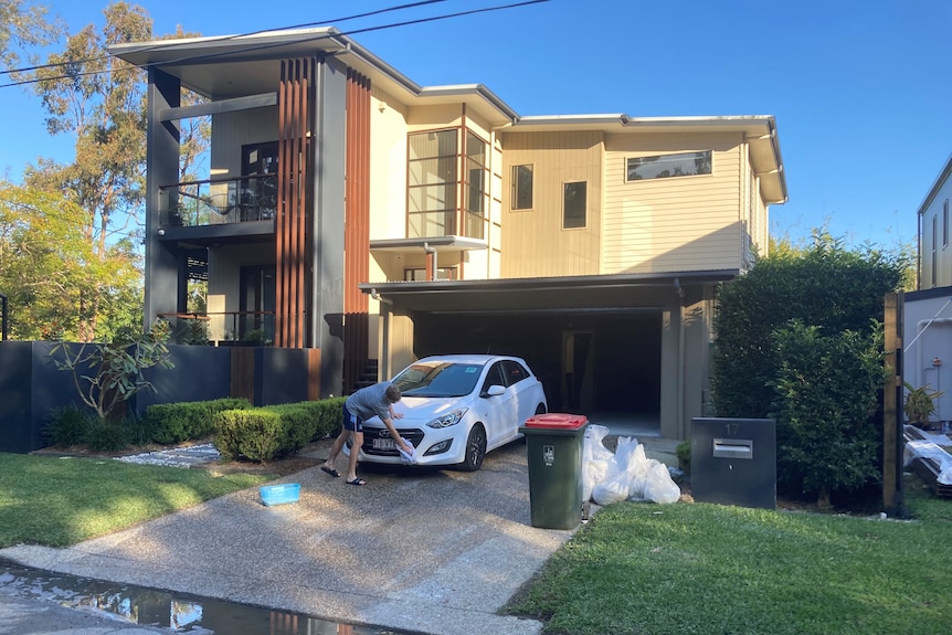 Lachlan Steedman washes his car in the driveway of his home at Ashgrove in Brisbane.