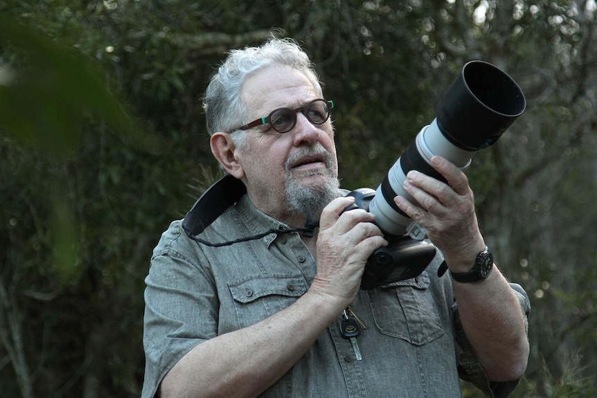 Wildlife Photographer Steve Parish holds a camera.