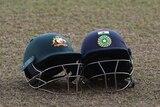 An India helmet and an Australia helmet next to each other on the grass