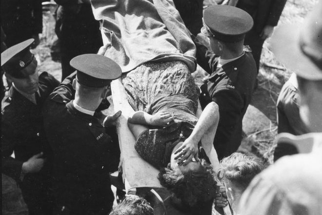 A survivor on a stretcher being carried from the wreckage of the rail crash at Camp Mountain in 1947.