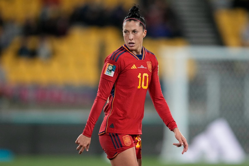 A woman on a sporting field looking on