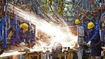 Sparks fly amid industrial workers.