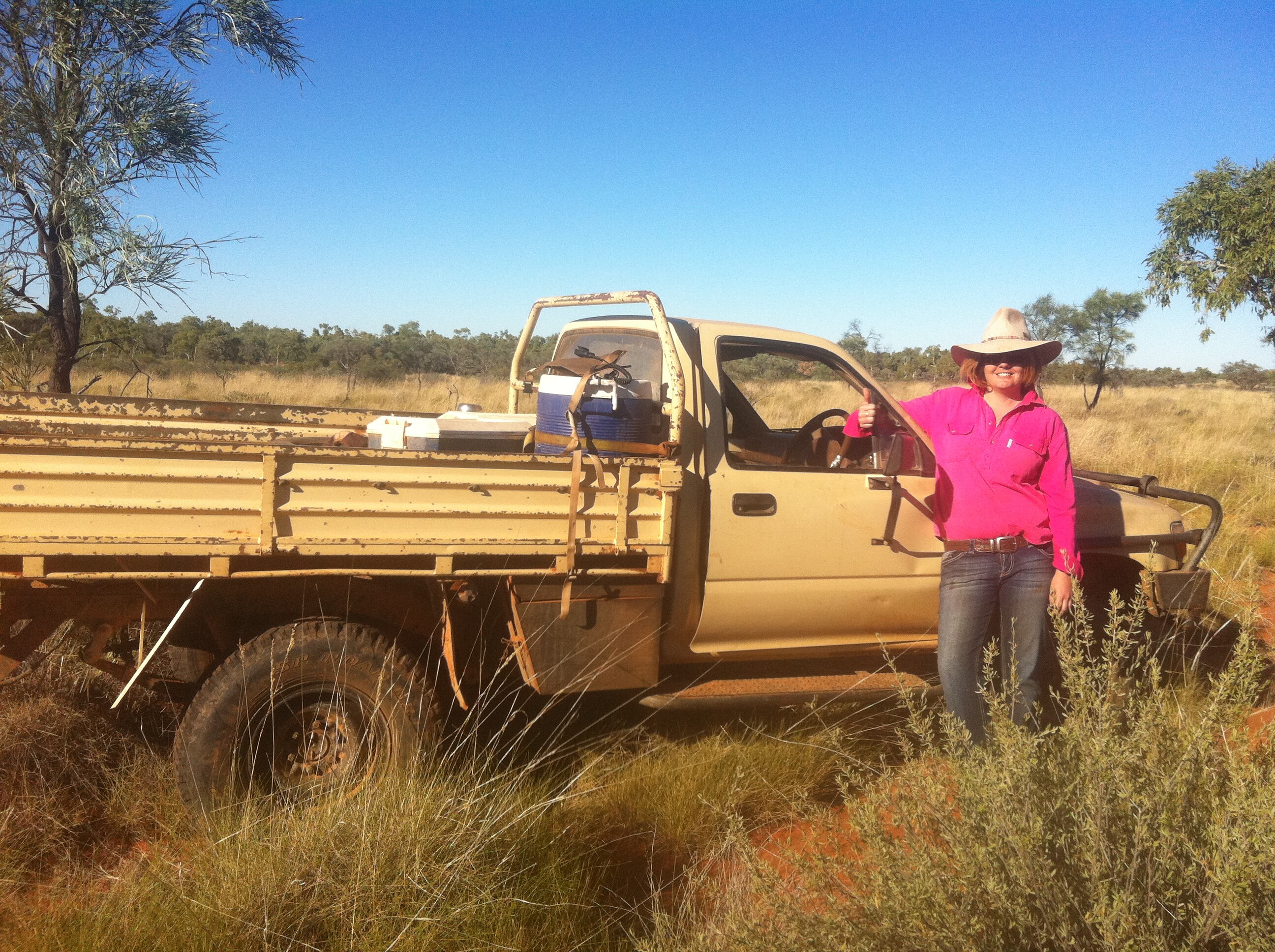 Katrina Fraser stands beside a ute in her days as a cook at an outback cattle station.