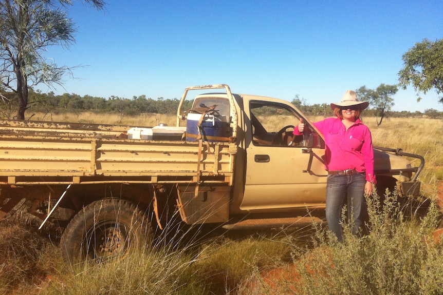 Katrina Fraser stands beside a ute in her days as a cook at an outback cattle station.