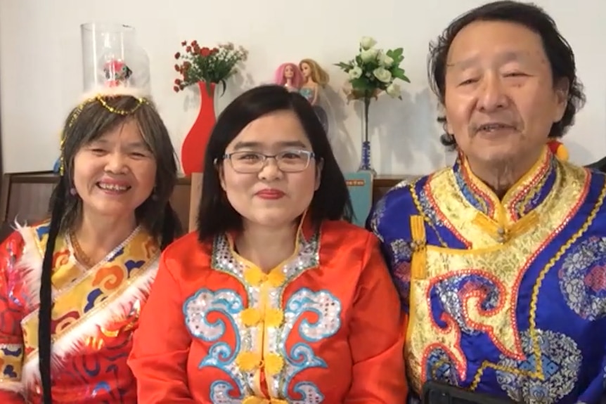 The Liu family dressed in traditional Manchu clothing sit in front of the family piano.