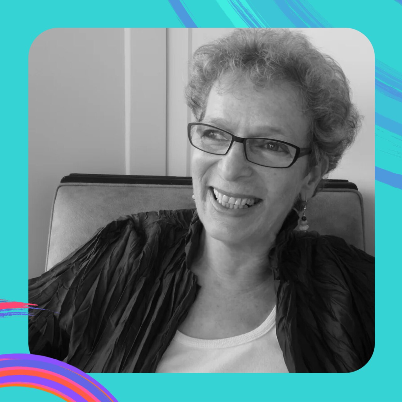 A black and white portrait of Susan Varga, who has short grey hair and is wearing eye glasses.