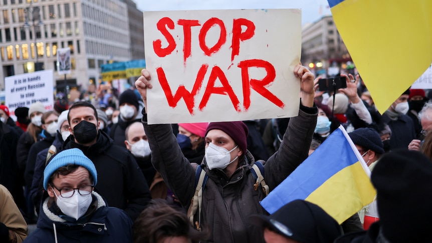 Demonstrators carry flags and banners during an anti-war protest.