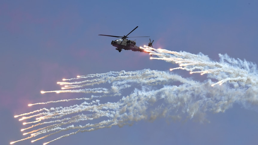 A helicopter surrounded by flares