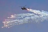 A helicopter surrounded by flares