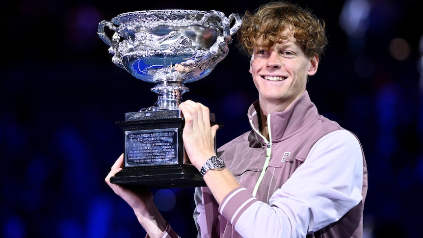 Jannik Sinner holds aloft the Australian Open trophy.