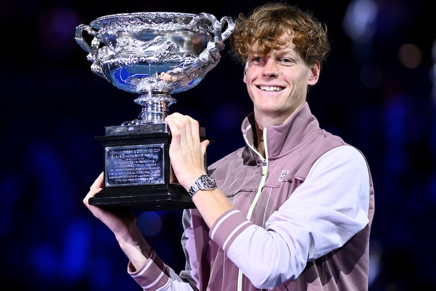 Jannik Sinner holds aloft the Australian Open trophy.