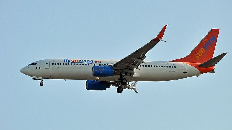 A Sunwing Airlines Boeing 737 flies in the air.