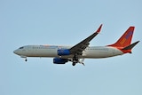 A Sunwing Airlines Boeing 737 flies in the air.