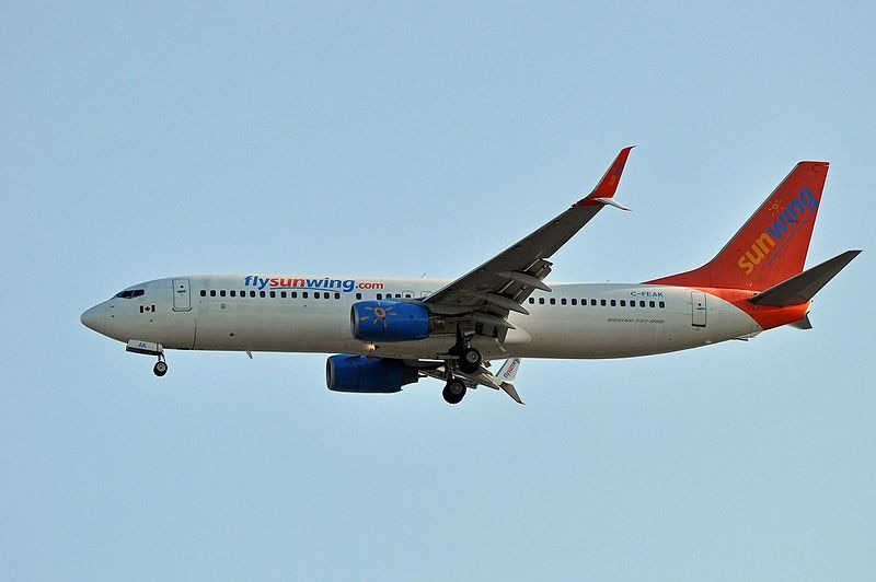 A Sunwing Airlines Boeing 737 flies in the air.