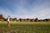 A Federals footballer stands on a football field on his own waiting for the play to come.