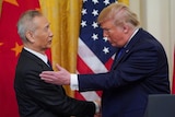 Donald trump and Liu He shacking hands.