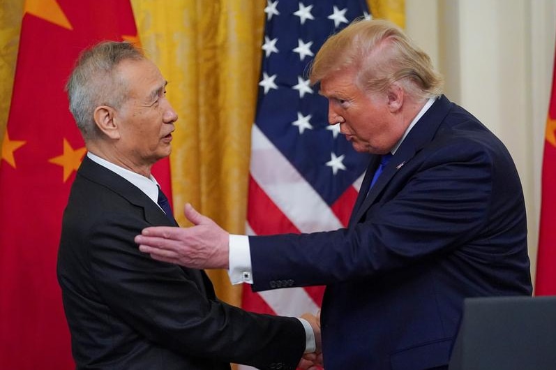 Donald trump and Liu He shacking hands.