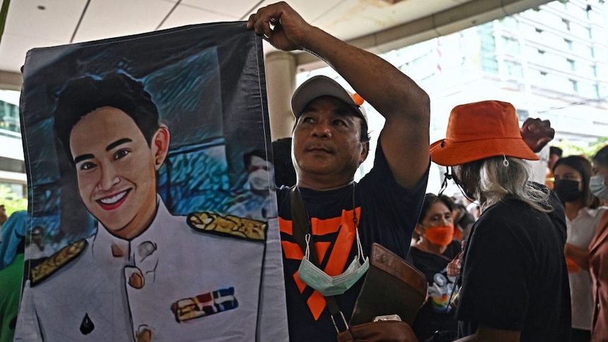 A Move Forward Party supporter holds a poster of leader Pita Limjaroenrat