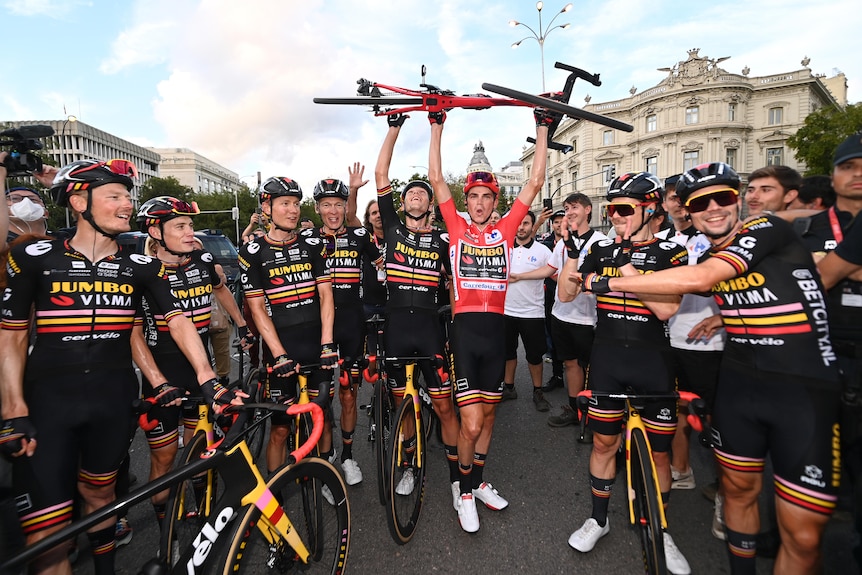 Sepp Kuss holds up his bike