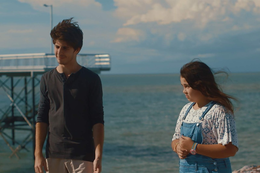 A still from the film We're Family now showing young actors Joseph Baronia and Journey Kelly standing near a beach.