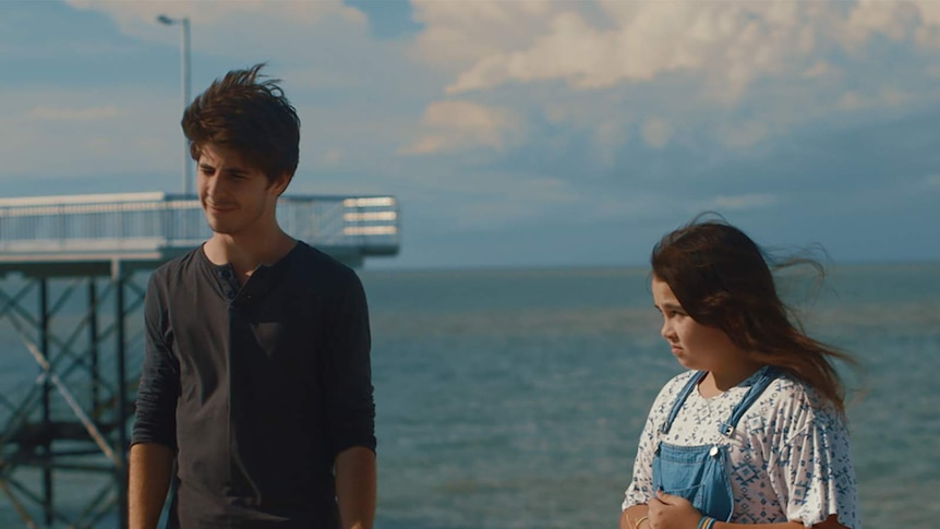 A still from the film We're Family now showing young actors Joseph Baronia and Journey Kelly standing near a beach.