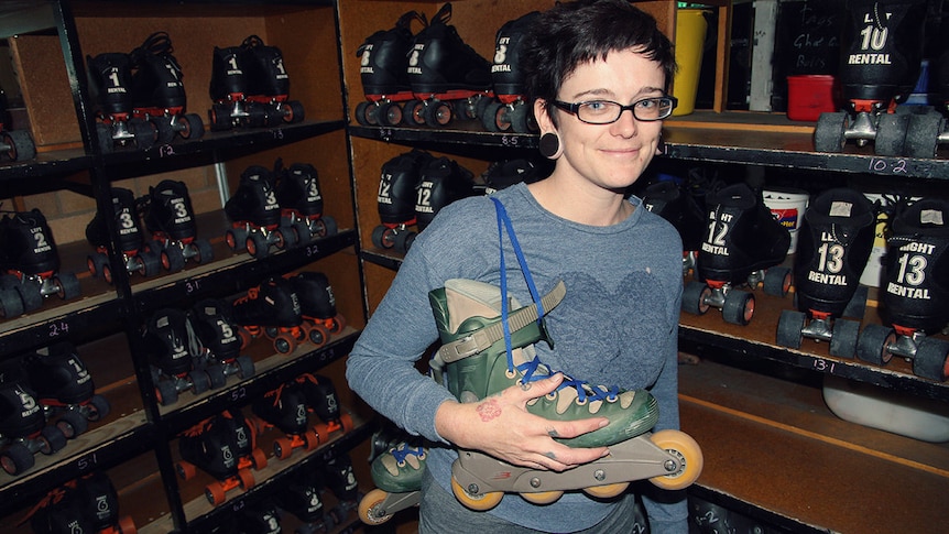 A woman stands in front of hire skates at the skate rink