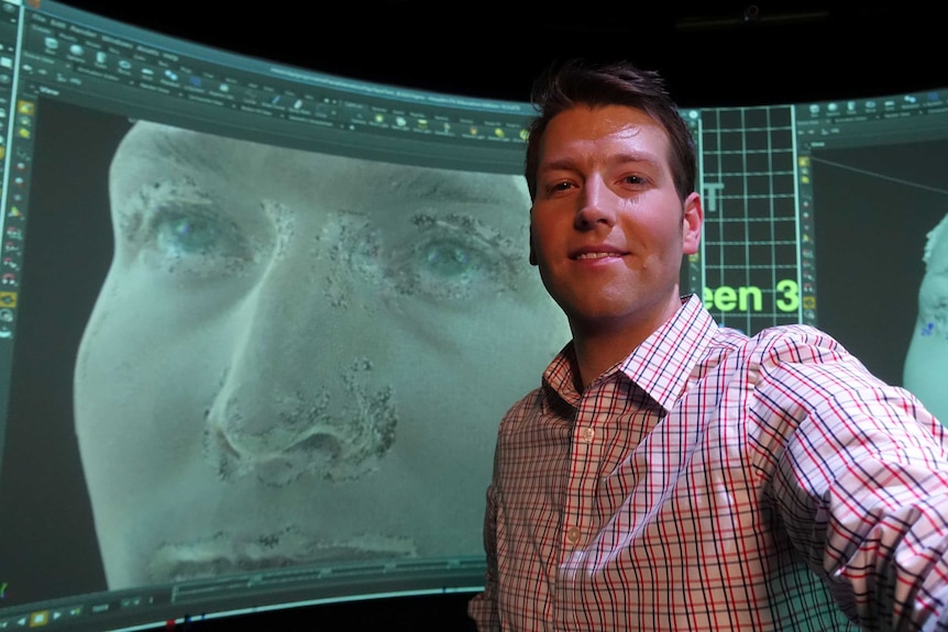 Reporter Jake Sturmer poses with an image of his scanned head