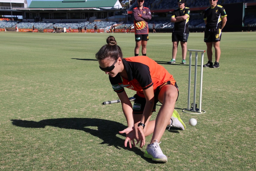 Perth Scorchers bowler Heather Graham attempts to field wearing blackout glasses used in blind cricket.