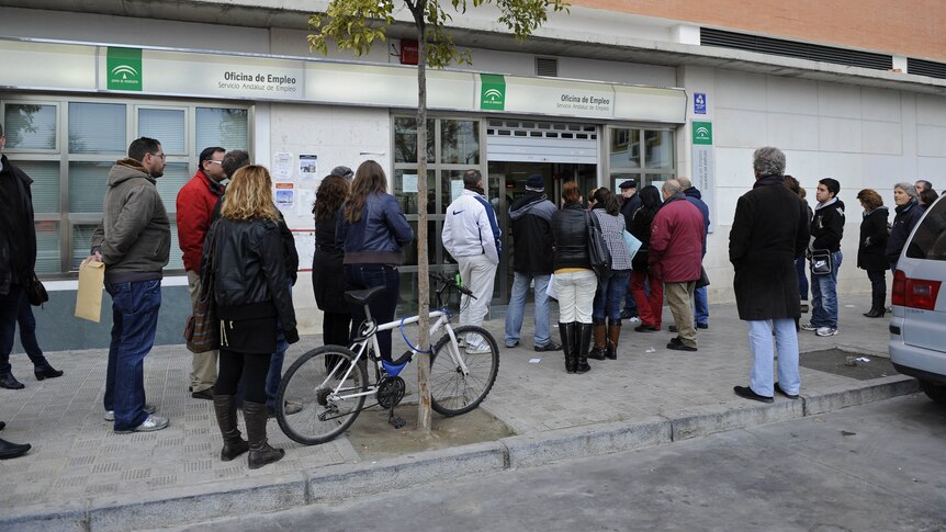 High unemployment: Spaniards wait in line in front of a government employment office in the Cruz Roja suburb of Seville.