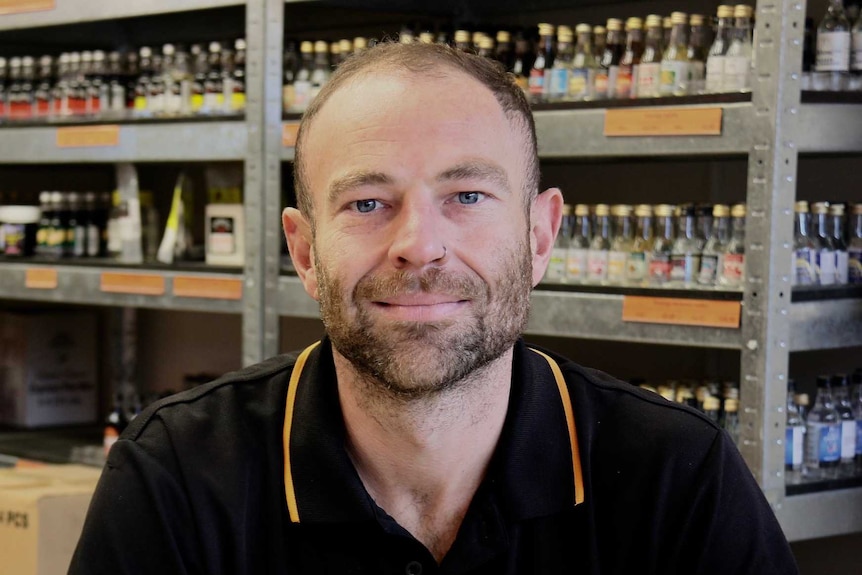 Adam Lincoln in front of brewing products.