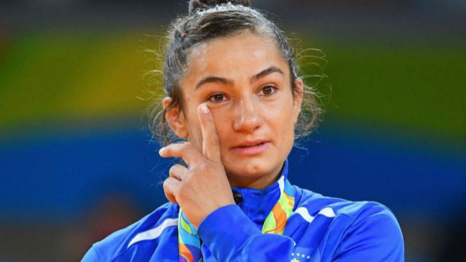 Majlinda Kelmendi, wearing her medal, wipes a tear from her eye. Photo: Getty Images