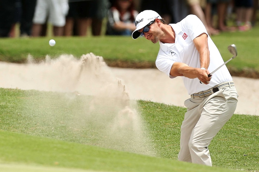 Nervous start ... Adam Scott plays a bunker shot on the first hole