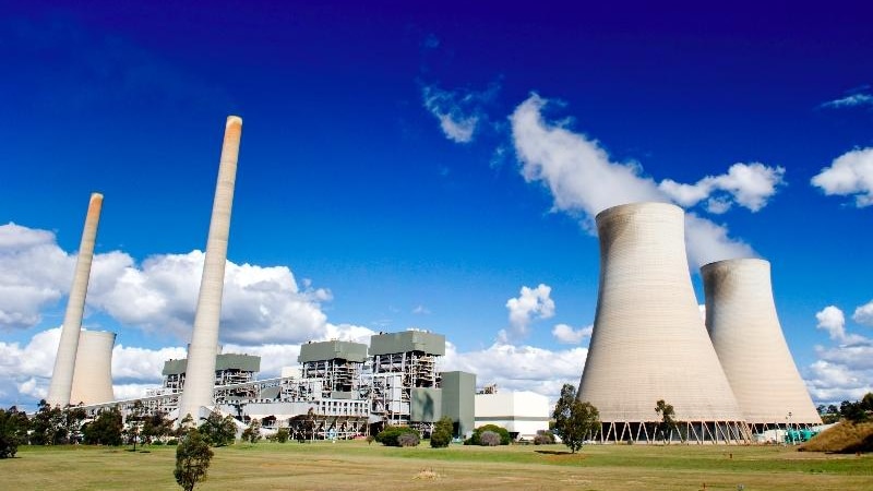 A coal-fired power station against a blue sky.