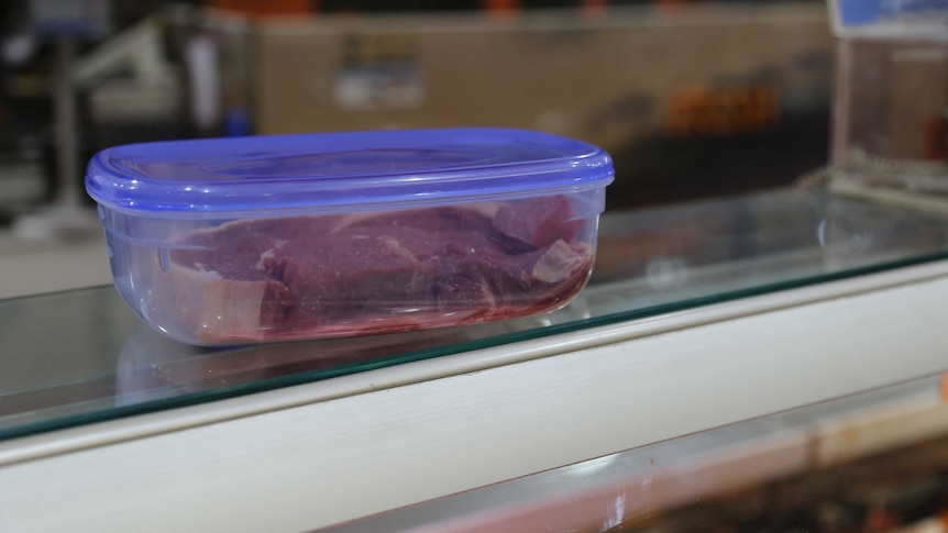 A piece of meat in a reusable plastic container at an Adelaide butcher