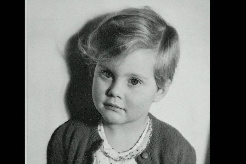 A black-and-white photograph of Olivia Newton-John as a young girl.
