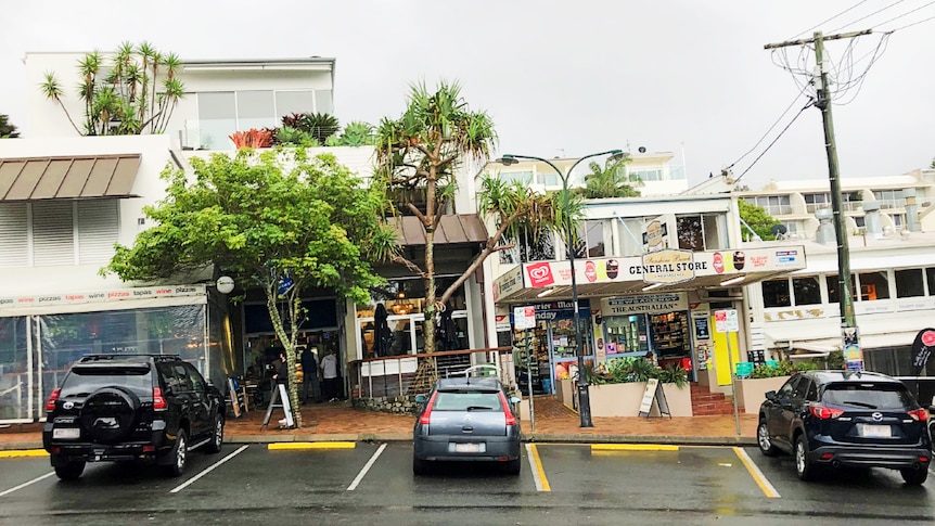 Row of shops with cars parked in front of them