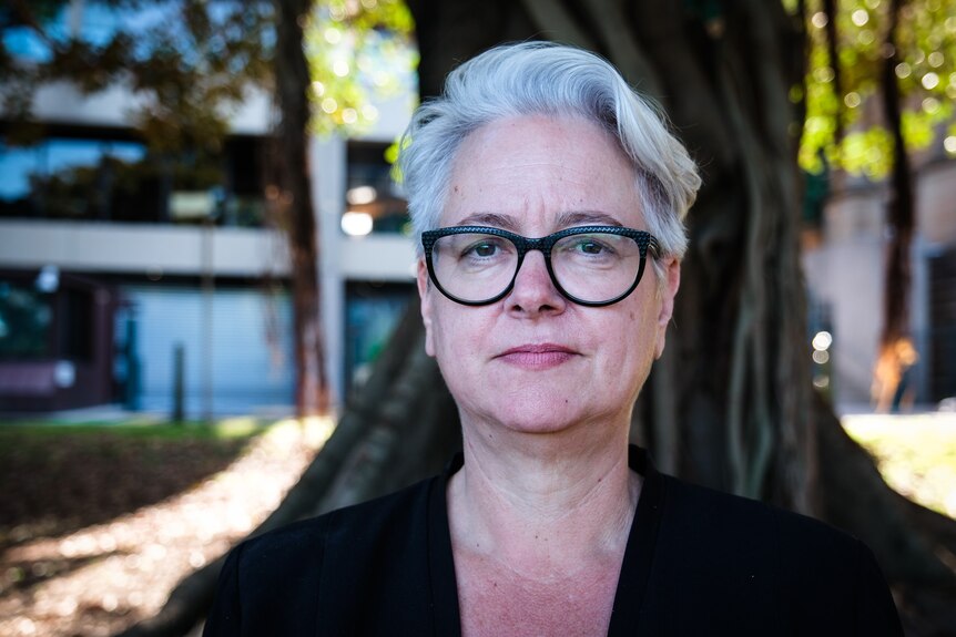 A woman with grey hair wearing glasses