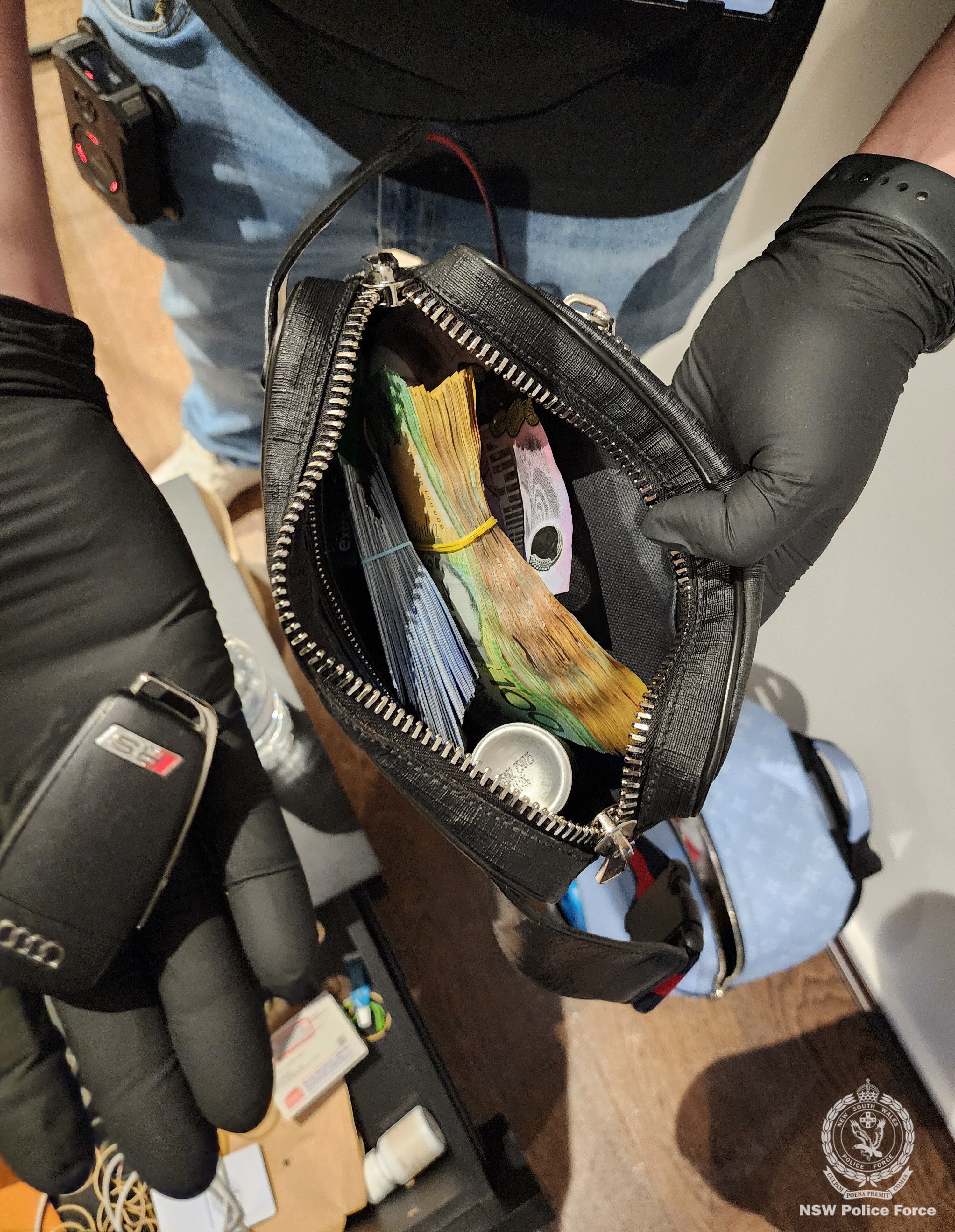 Un policía sostiene una bolsa llena de dinero en efectivo.