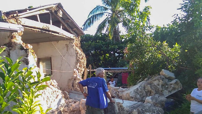 A resident looks at damaged houses in Itbayat town in northern Philippines following the earthquakes.