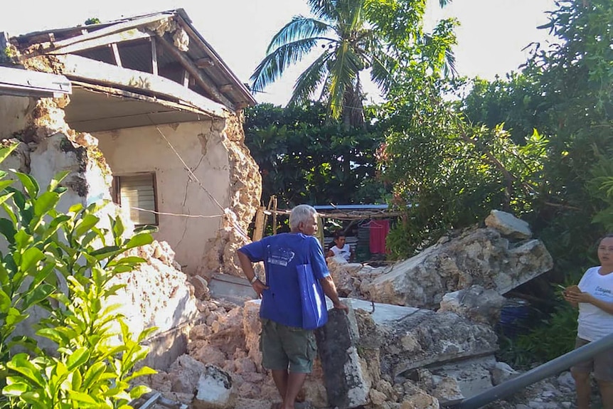 A resident looks at damaged houses in Itbayat town in northern Philippines following the earthquakes.