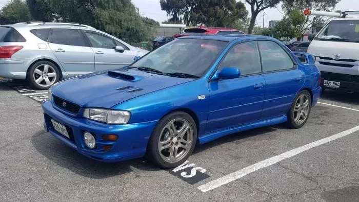 A blue sedan in a car park