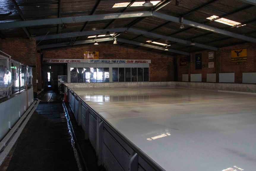 An empty indoor ice skating rink.