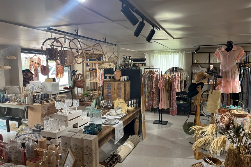 The inside of a shop displaying a variety of goods including clothing, kitchenware and candles.