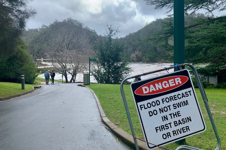 Warning sign due to elevated water levels at a public park.