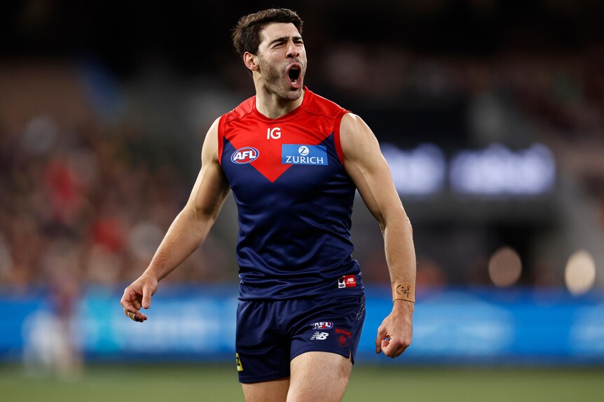 A Melbourne AFL player reacts as he celebrates a goal.