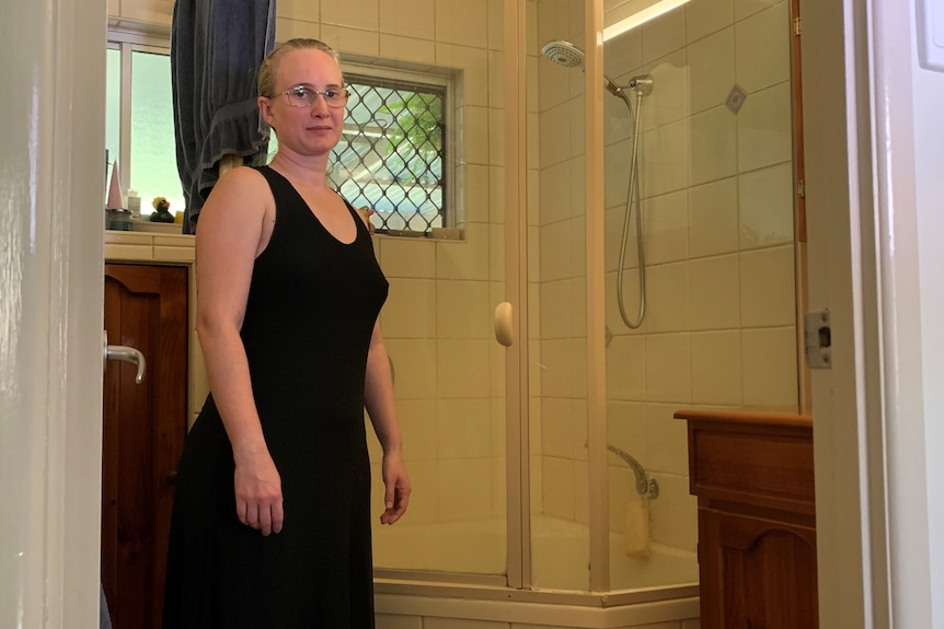 una mujer en un baño con bañera e inodoro