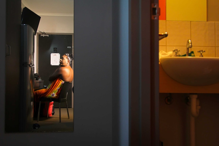 A photo of Shaniqua getting ready, as seen through a mirror in a hotel room.